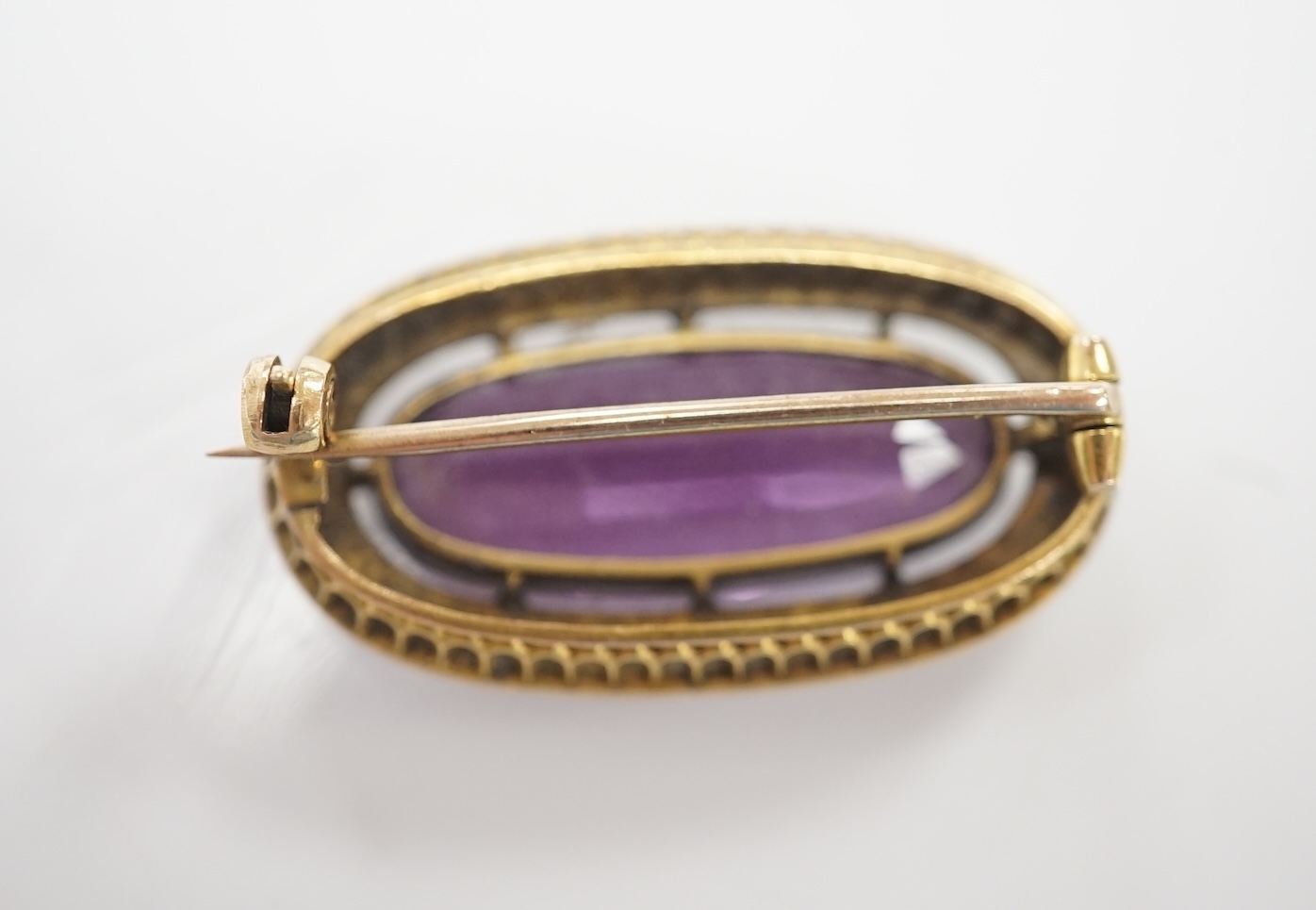 An early 20th century yellow metal mounted amethyst and split pearl cluster set oval brooch, 32mm, gross weight 8.8 grams. Condition - fair to good